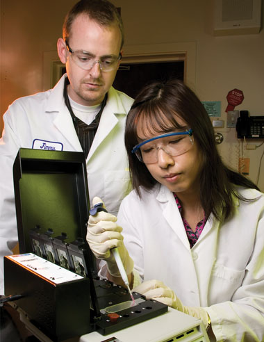 Environmental Report Biologists James Thissen (left) and Crystal Jaing work with a slide in the Lawrence Livermore Microbial Detection Array, which can detect greater than 5,000 different microbes. cover.