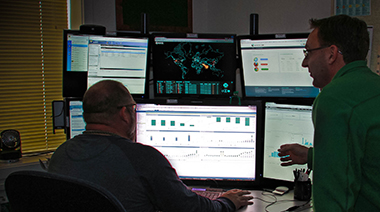 Cyber security analysts Patrick Stevens (left) and Darren Lynch discuss the use of SafeWeb—a tool to protect LLNL computers from malicious websites.