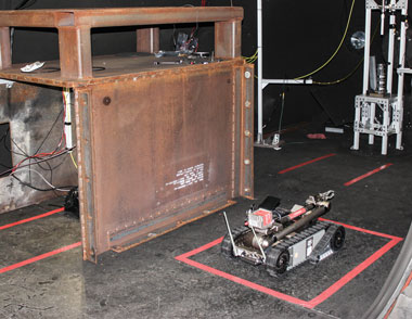Environmental Report Livermore Explosives iRobot (LEXI), shown in a firing tank at HEAF, is ready to move potentially unstable improvised explosives from a remote-controlled mixer inside a metal container (left) to a firing table (right). The tests of possible terrorist devices are conducted for the Department of Homeland Security. cover.