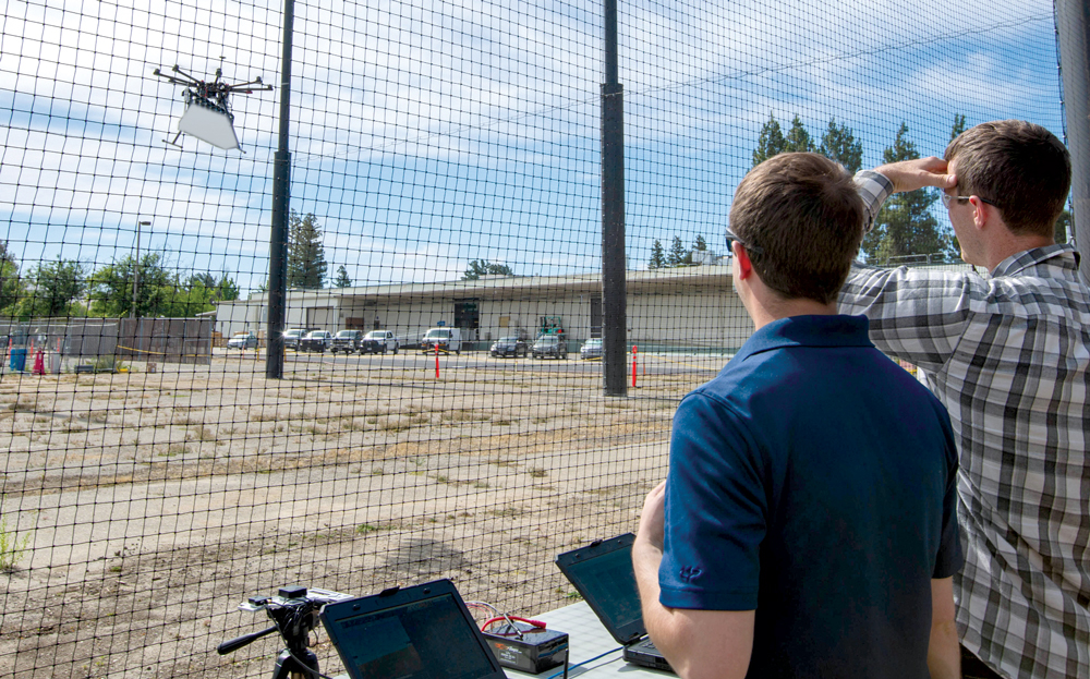 Collaborative autonomy researchers fly a drone under the netting at LLNL’s OS-150 Robotics Laboratory