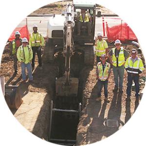 Work crews pose beside an excavation